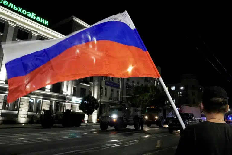 Un homme tient un drapeau russe alors que les combattants de Wagner se préparent à quitter la ville de Rostov, le 24 juin 2023
