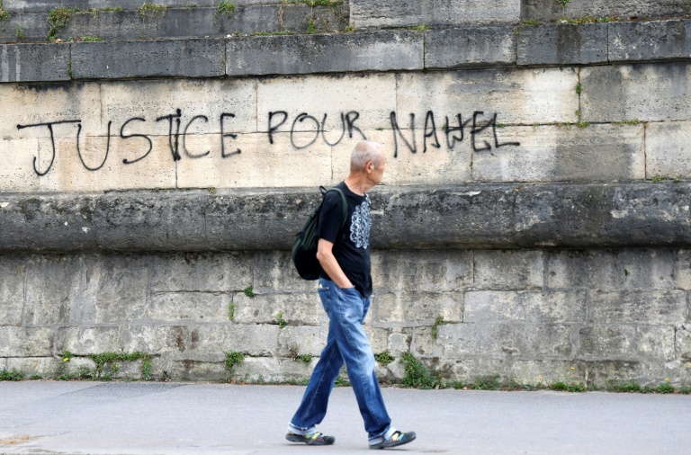 Un piéton passe devant un graffiti en hommage à Nahel, tué par un policier à Nanterre, le 1er juillet 2023 place de la Concorde à Paris